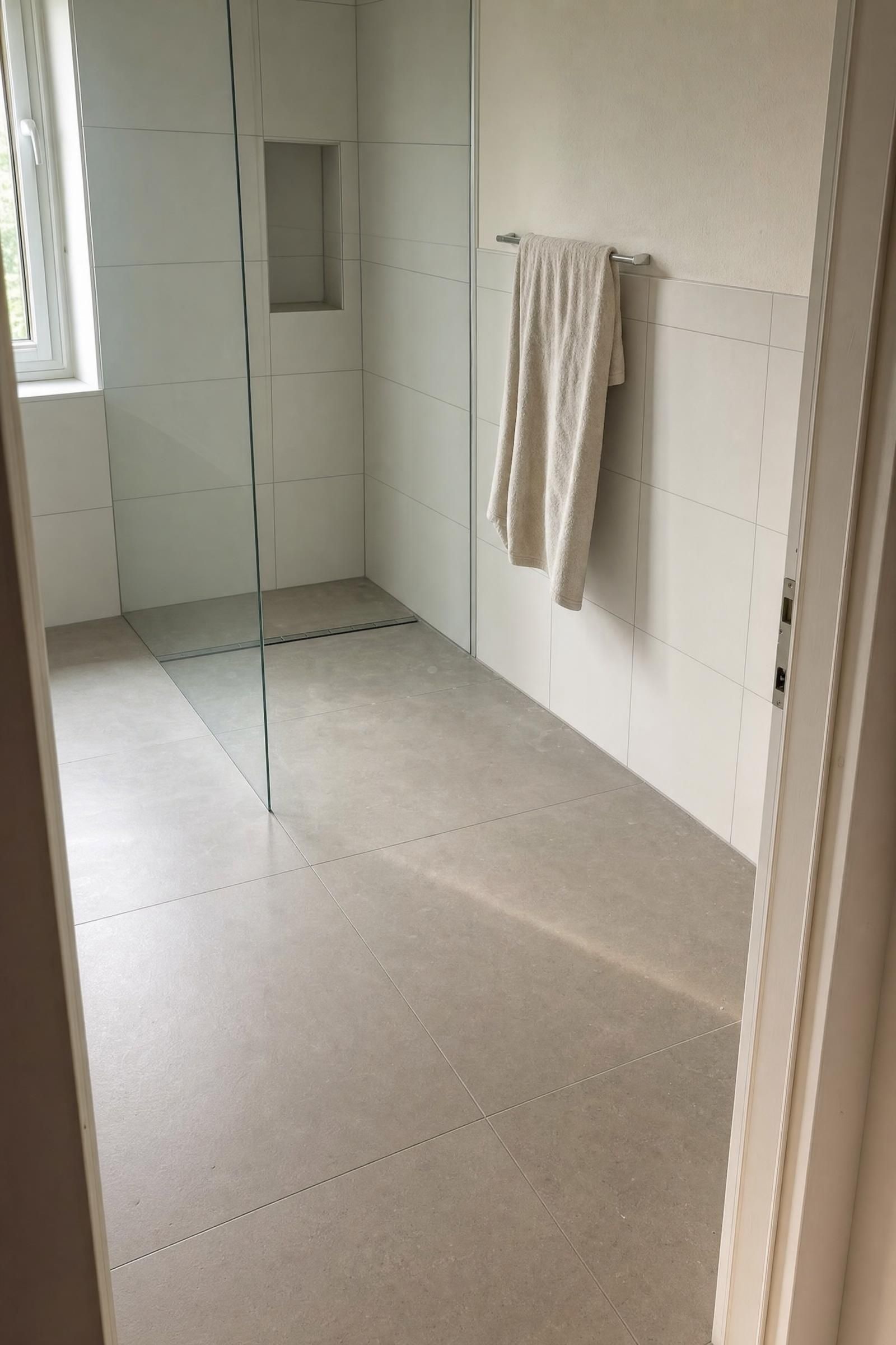 Badezimmer mit großformatigen Bodenfliesen und hellen Wandfliesen